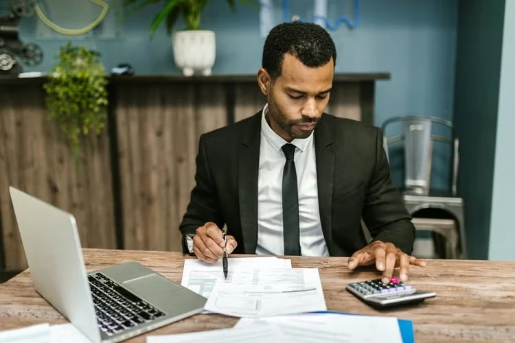 Accountant reviewing spreadsheets with daily transactions and balance sheets, showcasing tasks in hotel accounting.